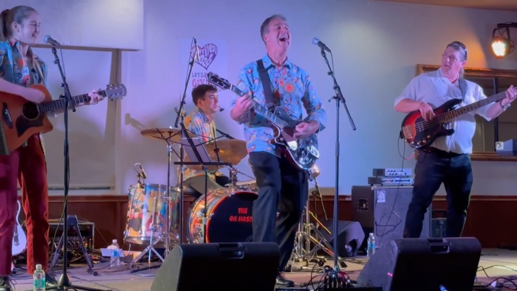 Members of By George on stage at Harrifest in 2024